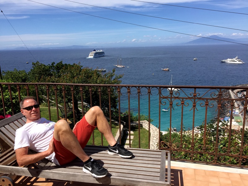 Clint enjoying the sites and sounds of Capri's Marina Grande from our Airbnb balcony