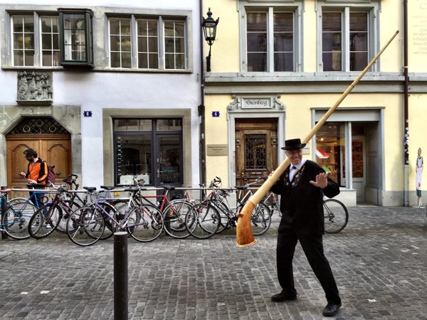 One of the alpine horn blowers taking his horn and splitting